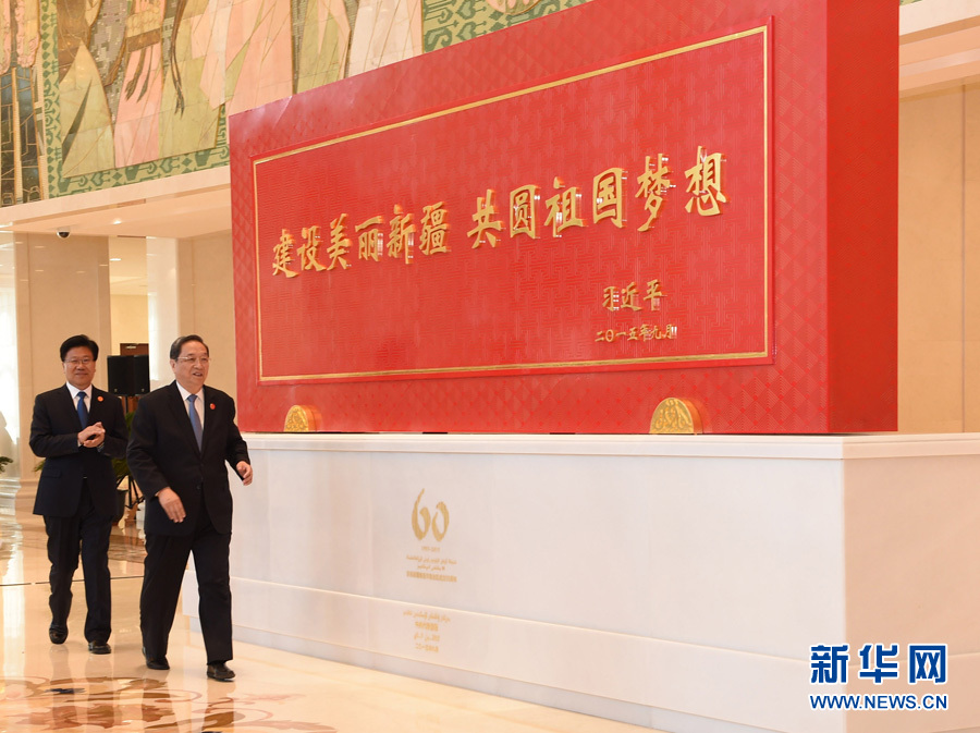 這是俞正聲和中共中央政治局委員、新疆維吾爾自治區黨委書記張春賢一同為習近平總書記題詞賀匾揭幕。新華社記者 高潔 攝 