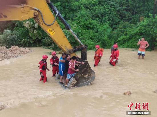 6月16日，因遭遇暴雨襲擊，廣西沿海多處發生嚴重內澇，居民被困。當地消防部門接到求助信息后，先后轉移被困的居民數十人。圖為利用鏟車運送被困居民。